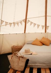 a bedroom with a bed with a straw hat on it at White House on Wye Glamping in Hereford