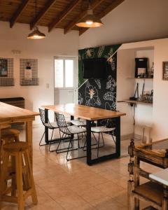 a dining room with a wooden table and chairs at Chepatagonia Hostel & Experiences in Puerto Madryn