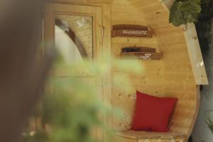 アウッゲンにあるWinzerhof Kellerの小さなお部屋で、木製の壁に赤い枕が備わります。