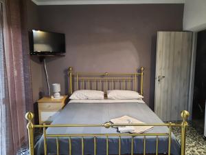 a bedroom with a bed with a tv on the wall at Villa Valentina b&b in Vicoforte