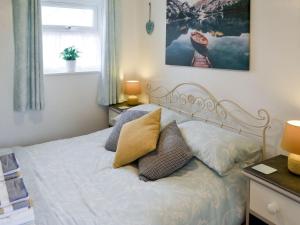 Un dormitorio con una cama con almohadas. en The Loft, en Amlwch