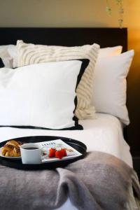 ein Tablett mit einem Teller Essen auf dem Bett in der Unterkunft Luxurious fully equipped Cowley 1 bed apartment with FREE Parking in Oxford