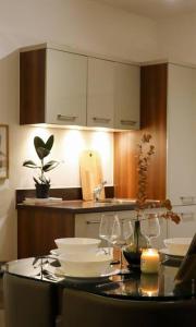 eine Küche mit einem Tisch mit Gläsern und einer Kerze in der Unterkunft Luxurious fully equipped Cowley 1 bed apartment with FREE Parking in Oxford