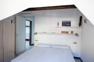 a bedroom with a white bed in a room at La mansarda sul Porto in Camogli