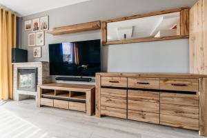 カリシュにあるNocosfera Apartament Stawiszyńskiのリビングルーム(テレビ、木製ドレッサー付)