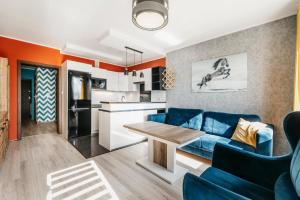 カリシュにあるNocosfera Apartament Stawiszyńskiの青いソファとキッチンのあるリビングルーム