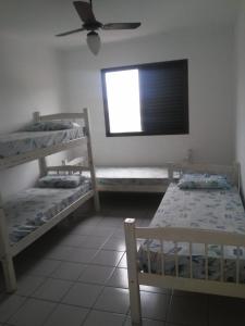 a room with two bunk beds and a window at Residencial Solar de Pernambuco in Guarujá