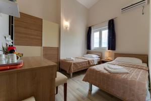 um quarto de hotel com duas camas e uma mesa com um balcão em Argyruntum Apartments em Starigrad-Paklenica