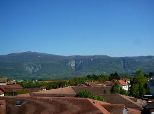 una ciudad con casas y montañas en el fondo en HYP'Hotel, en Saint-Marcellin