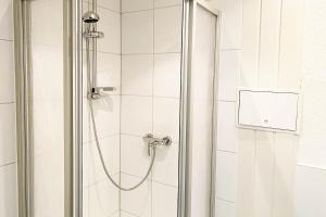 a shower with a hose in a bathroom at Work & Stay Apartment in Bitterfeld