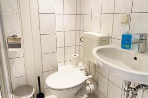 a white bathroom with a toilet and a sink at Perfekt für Monteure & Geschäftsreisende in Bitterfeld, Nähe Chemiepark & Industriegebiet in Bitterfeld +1 photo