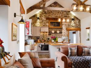 uma cozinha e sala de estar com mobiliário de couro castanho em Sgubor Llwyndu em Bettws