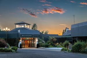 a resort building with a sunset in the background at Rosspark Hotel Kells in Ballymena