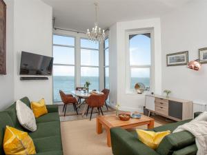 a living room with a green couch and a table at Bullens Rock in Ilfracombe