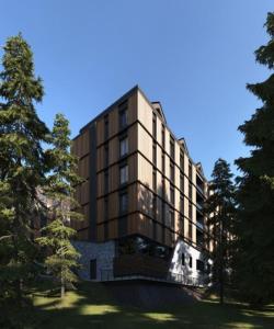 a large building with trees in front of it at Select Lux Woodside Residences & SPA in Kopaonik