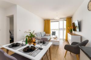 kuchnia i salon ze stołem i krzesłami w obiekcie Apartament Słoneczny przy morzu z klimatyzacja w Grzybowie