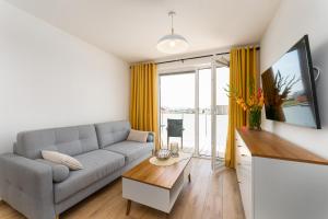 salon z kanapą i stołem w obiekcie Apartament Słoneczny przy morzu z klimatyzacja w Grzybowie