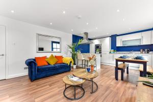 a living room with a blue couch and a kitchen at Spacious Cosy 2 Bed Flat, Central London in London