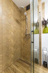 prysznic ze szklanymi drzwiami i stołem w obiekcie Apartament Słoneczny przy morzu z klimatyzacja w Grzybowie