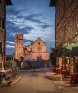 a building with a clock tower and a church at Francesco House Family in Assisi