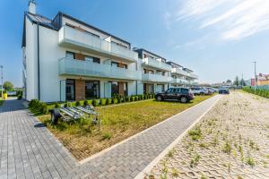 budynek z zaparkowanymi przed nim samochodami w obiekcie Apartament Słoneczny przy morzu z klimatyzacja w Grzybowie