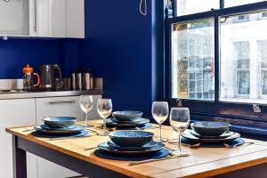 uma mesa com pratos, taças e copos de vinho em Spacious Cosy 2 Bed Flat, Central London em Londres
