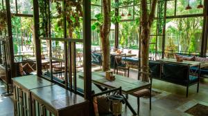ein Restaurant mit Tischen und Stühlen in einem Raum mit Fenstern in der Unterkunft VOGUE HOTEL RESORT AND SPA - Nabran in Nabran