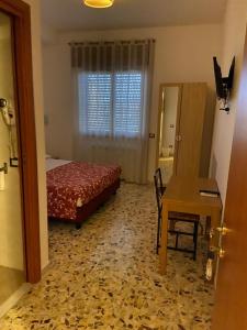 sypialnia z łóżkiem, stołem i biurkiem w obiekcie Villa Alma w mieście Fiumicino