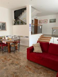 salon z czerwoną kanapą i stołem w obiekcie Villa Alma w mieście Fiumicino