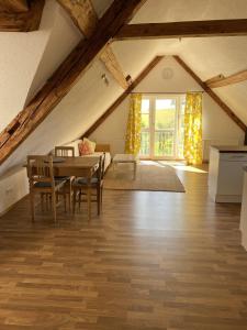 a room with a table and chairs in a attic at Ferienhof Weber Nieratz in Wangen im Allgäu