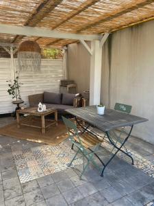 a patio with a table and a couch at Adorable chambre vue sur piscine in Béziers