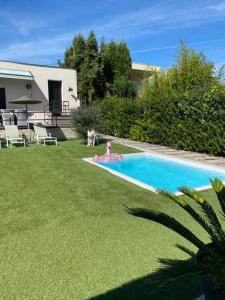 a person laying in a swimming pool in a yard at Adorable chambre vue sur piscine in Béziers