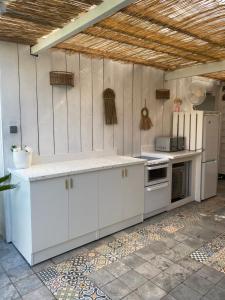 a kitchen with white cabinets and a white refrigerator at Adorable chambre vue sur piscine in Béziers