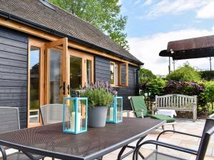 eine Terrasse mit einem Tisch und Stühlen sowie ein Haus in der Unterkunft Belfield in Canon Frome