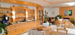 a restaurant with a counter and a table and chairs at Margun - Apartments & PanoramaRooms in Malles Venosta