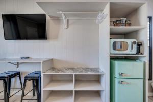 a kitchen with a refrigerator and a microwave at Dolphin Oceanfront Motel - Nags Head in Nags Head