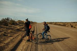 two people on bikes on a dirt road at Chepatagonia Hostel & Coworking in Puerto Madryn +31 photos