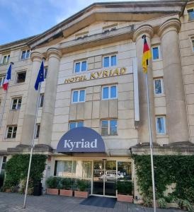 un bâtiment avec drapeaux devant lui dans l'établissement Kyriad Hotel Montpellier Centre Antigone, à Montpellier