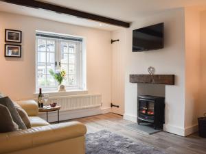 a living room with a couch and a fireplace at Manor Cottage in Findon