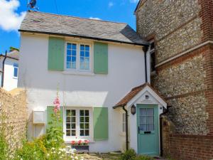 a white and green house with green shutters at Manor Cottage in Findon