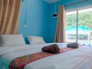 um quarto com 2 camas e uma grande janela em Baan seefa homestay kohyaoyai em Ko Yao Yai
