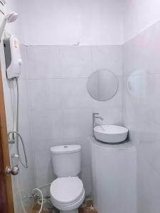 La salle de bains blanche est pourvue de toilettes et d'un lavabo. dans l'établissement Baan seefa homestay kohyaoyai, à Ko Yao Yai
