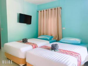2 camas individuais num quarto com uma televisão em Baan seefa homestay kohyaoyai em Ko Yao Yai