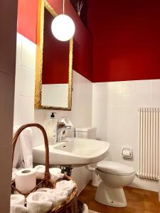 een badkamer met een wastafel, een toilet en een spiegel bij Ameiserhof Guesthouse in Collalbo