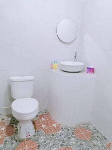 La salle de bains est pourvue de toilettes blanches et d'un lavabo. dans l'établissement Baan seefa homestay kohyaoyai, à Ko Yao Yai