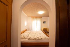 a bedroom with a bed with an archway at Ameiserhof Guesthouse in Collalbo