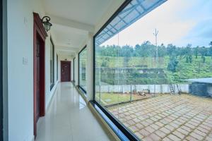 a large window in a room with a view of a yard at Thekkady Gavi Suites in Vandiperiyār