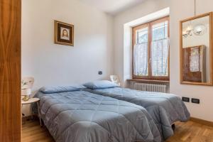1 dormitorio con 2 camas y ventana en Appartamento Tra i Due Laghi, en Baselga di Pinè