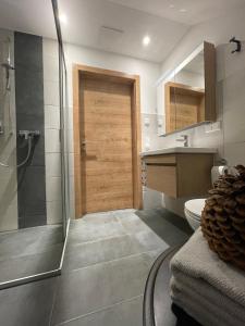 Łazienka z prysznicem i drewnianymi drzwiami w obiekcie Larix Apartment w mieście Tamsweg