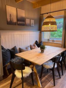 jadalnia z drewnianym stołem i kanapą w obiekcie Larix Apartment w mieście Tamsweg